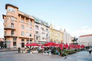 a market in a city with red umbrellas at Karlo Main Square Apartments in Zagreb