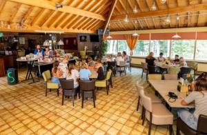 a group of people sitting at tables in a restaurant at Siblu de Tol in Nunspeet
