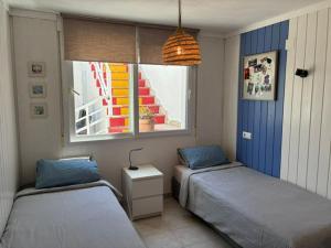 a bedroom with two beds and a window with a stair at Ons Spanje in Calpe