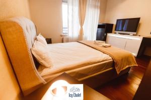 ein Hotelzimmer mit Bett und Fernseher in der Unterkunft Icy Chalet in Predeal