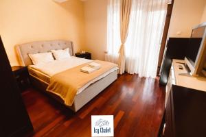 ein Schlafzimmer mit einem Bett und einem Fernseher in einem Zimmer in der Unterkunft Icy Chalet in Predeal