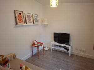 a living room with a tv and a table at L'ESPOIRENTHESE T2 35m2 in Nieuil-lʼEspoir