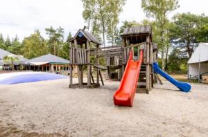a playground with a slide and a play structure at Siblu de Tol in Nunspeet
