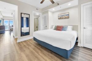 a bedroom with a large bed with white sheets and pillows at Carillon Beach Inn 310 in Panama City Beach +28 photos