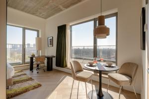 a living room with a table and chairs and windows at Makerstoren Short stay serviced apartments for 28 to 180 days in Amsterdam