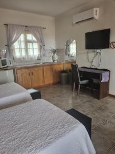 a hotel room with two beds and a desk and a television at Boschdal Upmarket Guesthouse in Rustenburg