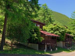 a cabin in the woods with a tree at Maruta なんもく村 in Minamimaki