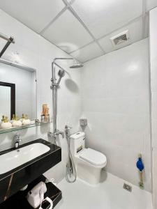 a white bathroom with a toilet and a sink at Aurora Homestay in Hanoi +50 photos