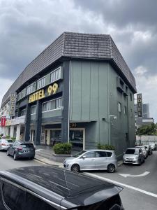 a building with cars parked in a parking lot at Hotel 99 Kepong in Kuala Lumpur