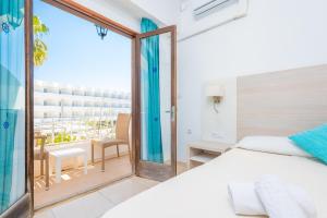 a bedroom with a bed and a balcony at Hotel Antares in Cala d´Or