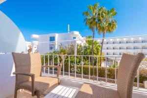 a balcony with two chairs and a building at Hotel Antares in Cala d´Or