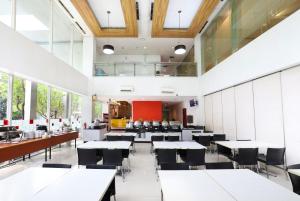 a dining room with tables and chairs and windows at Amaris Hotel Bekasi Barat in Bekasi +10 photos