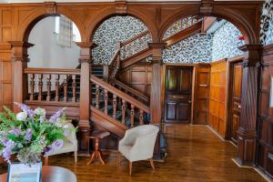 a hallway with a staircase and a vase of flowers at Rutland Hall Hotel & Spa in Oakham
