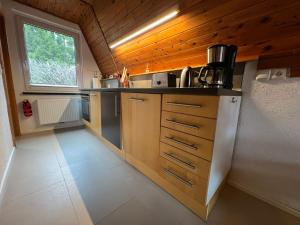 a small kitchen with wooden cabinets and a window at Ostseeferienhaus Finni in Ribnitz-Damgarten