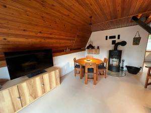 a living room with a table and a large television at Ostseeferienhaus Finni in Ribnitz-Damgarten