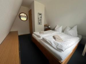 a bedroom with a large bed with white sheets at Ostseeferienhaus Finni in Ribnitz-Damgarten