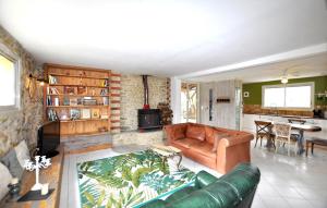 a living room with a leather couch and a table at Authentique Maison Piscine in La Cassaigne