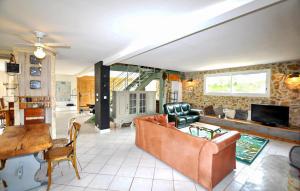 a living room with a couch and a tv at Authentique Maison Piscine in La Cassaigne