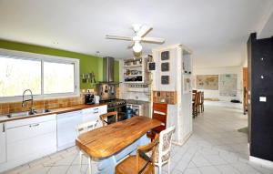 a kitchen with a wooden table and a dining room at Authentique Maison Piscine in La Cassaigne