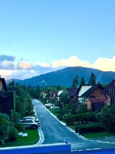 a street in a town with houses and a car at Casa Del Cielo in Jarabacoa +4 photos