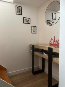 a room with a table and a mirror on the wall at Au Petit Stub, studio 2 étoiles in Rosheim