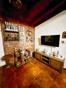 a living room with a brick wall with a tv at Casa Del Cielo in Jarabacoa