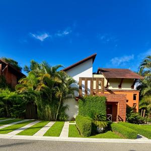 a house with trees and bushes in front of it at Casa Del Cielo in Jarabacoa