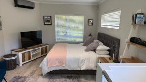a bedroom with a bed and a flat screen tv at Hack's Shack in Cape Town
