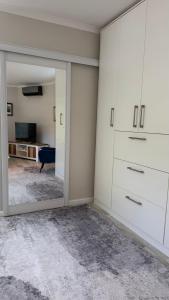 a room with white cabinets and a mirror at Hack's Shack in Cape Town