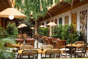 an empty restaurant with tables and chairs and plants at Radisson Blu Hotel, Dubai Deira Creek in Dubai