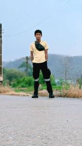 a man standing on the side of a road with his knee brace at Wai zin in Sara Buri
