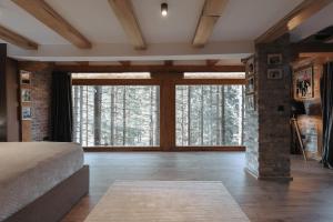 a bedroom with a bed and a large window at Seraphine Chalet in Peje