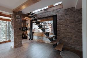 a living room with a brick wall and a staircase at Seraphine Chalet in Peje
