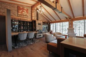 a living room with a bar and some chairs at Seraphine Chalet in Peje