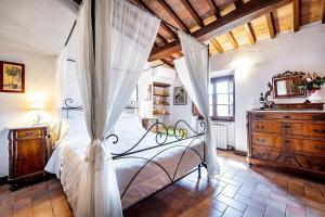 a bedroom with a canopy bed and a dresser at Agriturismo Poggiacolle in San Gimignano