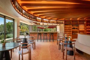 a restaurant with wooden ceilings and tables and chairs at Gran Hotel Mas d'en Bruno in Gratallops