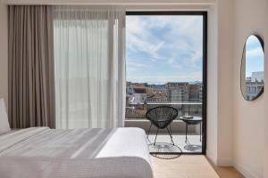a bedroom with a bed and a large window at September Athens Residences in Athens