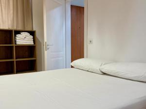 a white bed in a room with a closet at SĀN Living in Golem