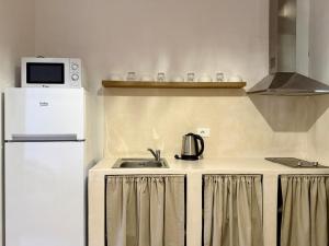 a kitchen with a white refrigerator and a sink at SĀN Living in Golem