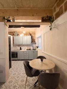 a kitchen with a table and chairs in a room at Ta' Marta Lodge in Victoria