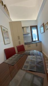 a kitchen with a glass table and red chairs at Apartamento Banesto in Chinchón