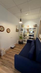 a living room with a blue couch and wooden floors at Apartamento Banesto in Chinchón