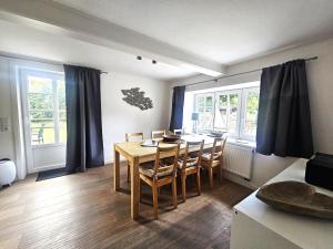 a living room with a dining room table and chairs at Uijs Hüs in Borgsum