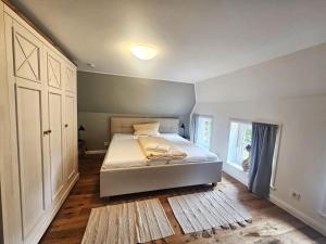 a bedroom with a white bed and a window at Uijs Hüs in Borgsum