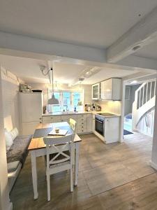 a kitchen with white cabinets and a table and chairs at WattLütt in Oevenum