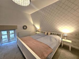 a bedroom with a large bed and two tables with lamps at WattLütt in Oevenum
