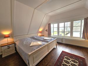 a bedroom with a large bed and two windows at Ilskes Hus in Oevenum
