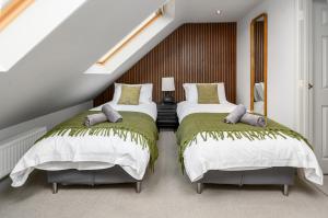 two beds in a room with a staircase at The Castle Suite 24h Gym Free Parking in Kenilworth