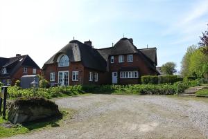 a large red brick house with a driveway at Pastoratshof - Haus 6 in Wrixum
