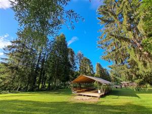 a gazebo in the middle of a field with trees at Camping Les Pommiers in Comblain-au-Pont